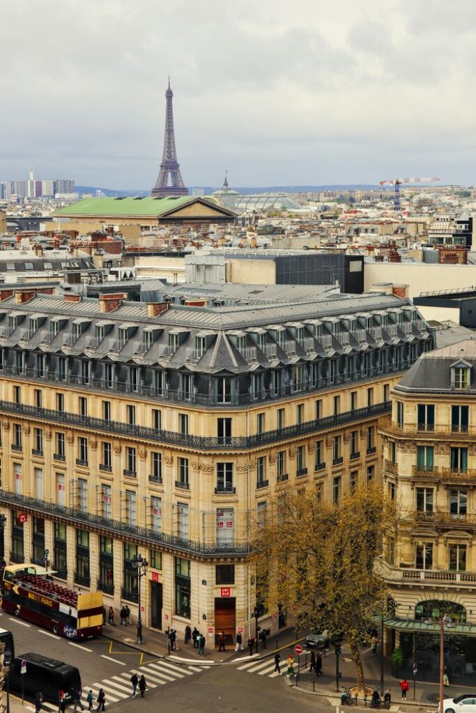 Aerial view of Paris streets and buildings with Eiffel Tower in the background.